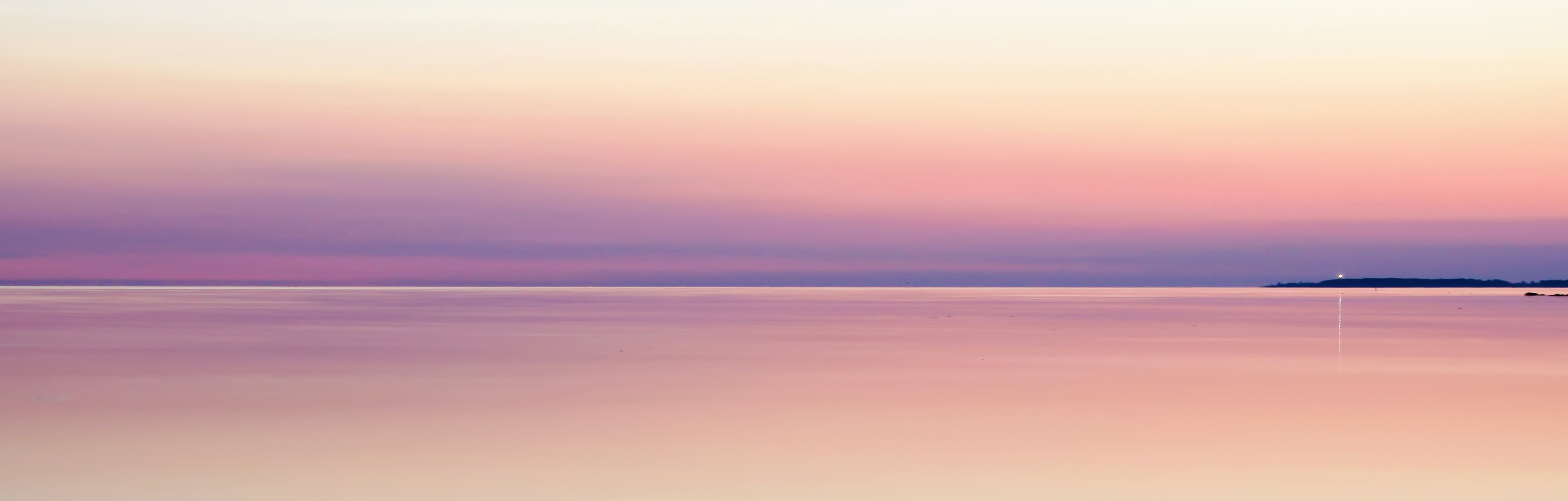 A landscape image of purple/pink sky and water.