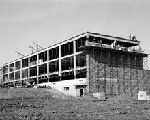 A Black and white photo of a building under construction.